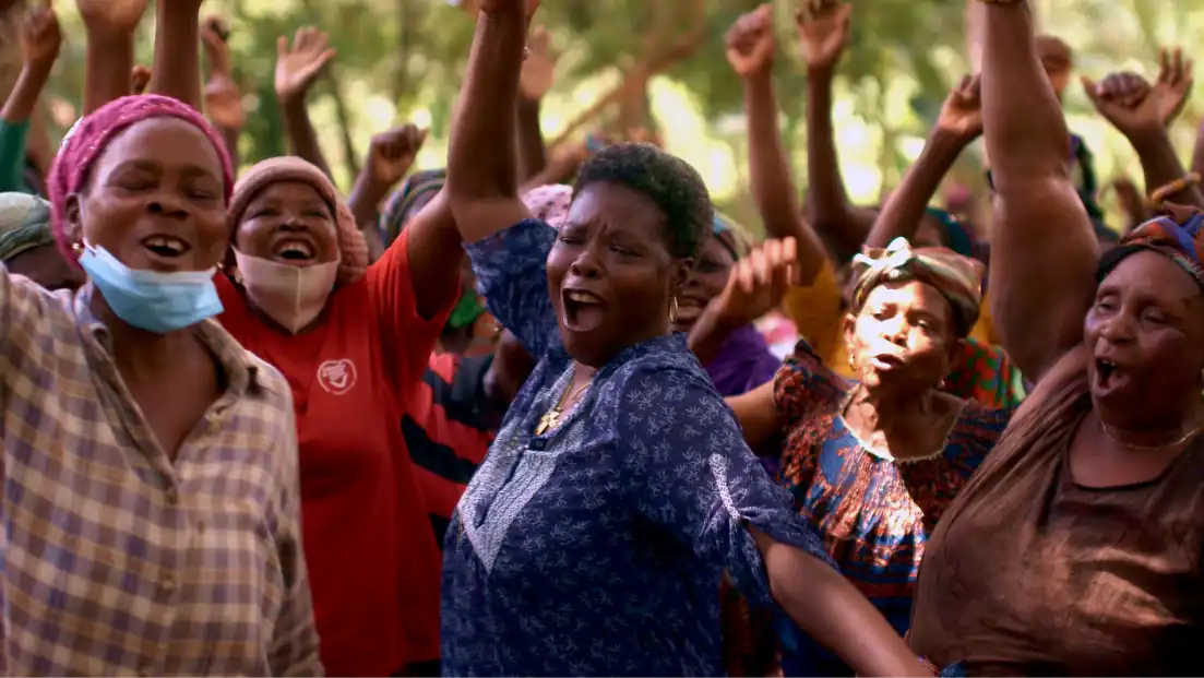Group of joyful women dancing outdoors with arms raised