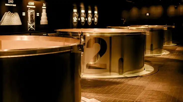 Large metallic circular structures numbered 1 and 2 in a dimly lit exhibition space.